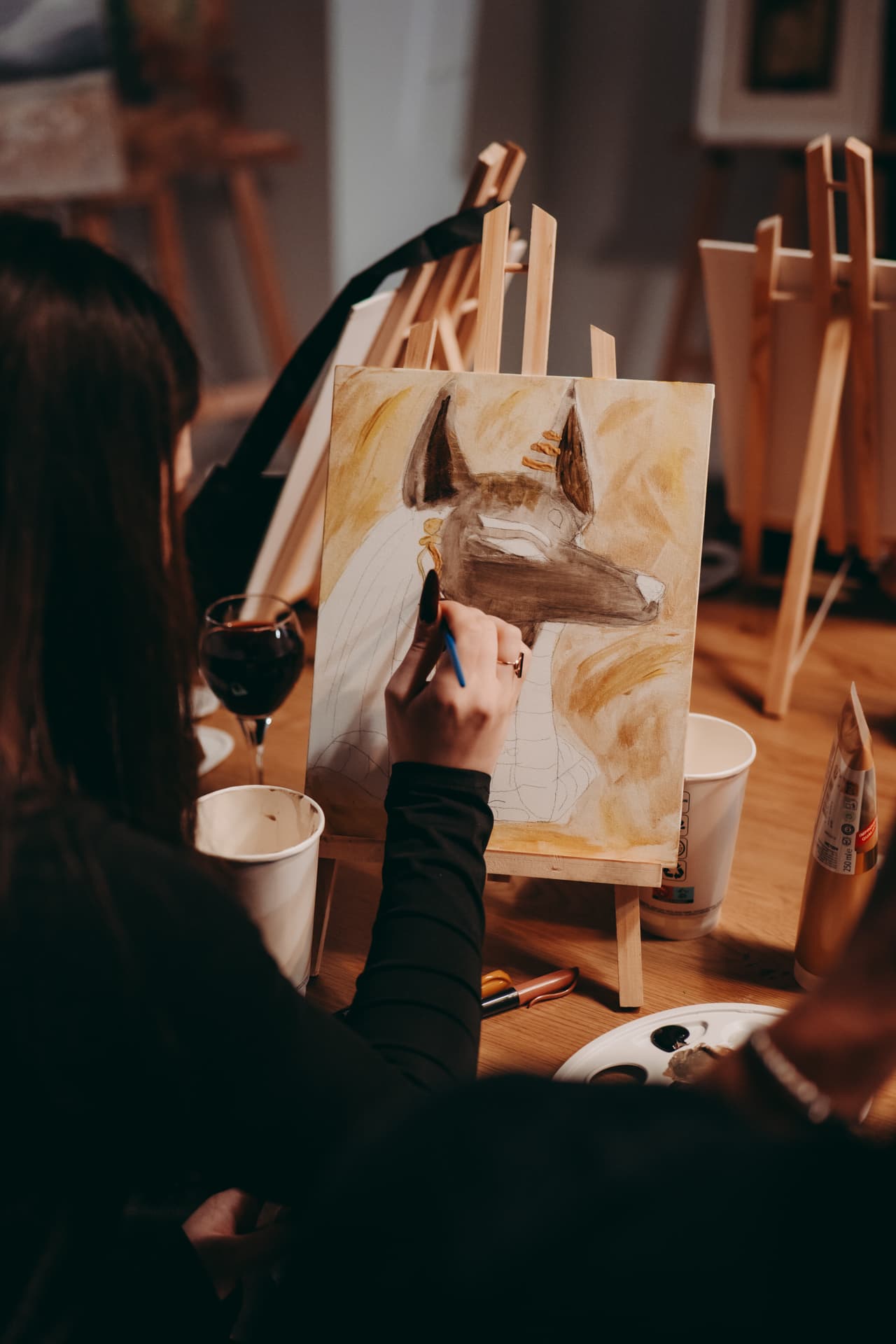A guest working on a painting during Sip and Paint Krakow