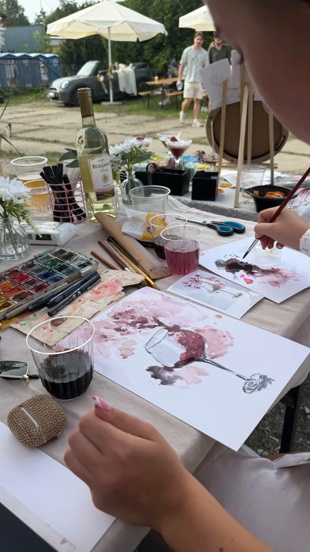 Guest creating a wine-glass illustration during a wine-painting workshop